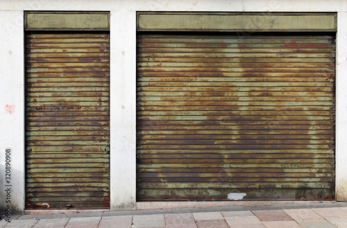 Old closed green metal rolling shutters on an old building