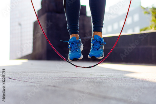 Close up of an athletic person's feet jumping rope outdoor