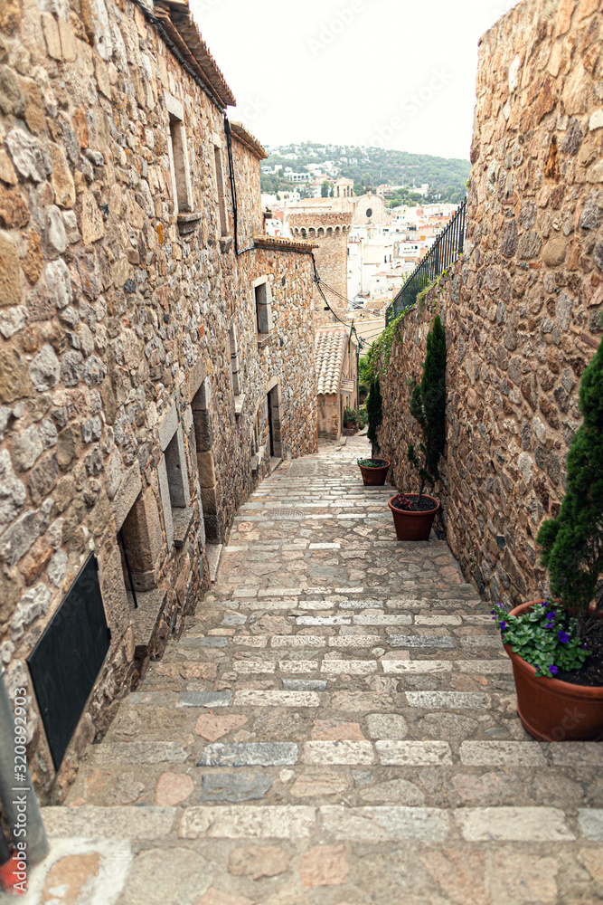 Stone steps up on a narrow street in an old European city in Spain.