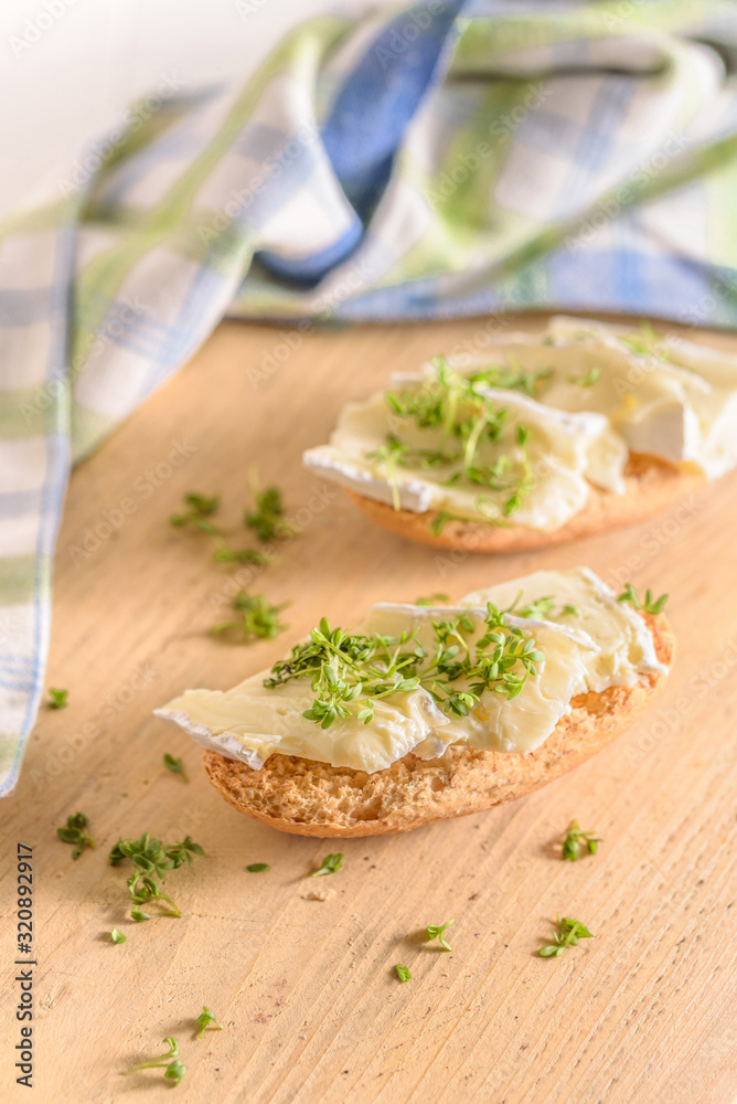 Ein belegtes Brötchen mit Cemembert und Kresse Ein belegtes Brötchen mit Cemembert und Kresse
