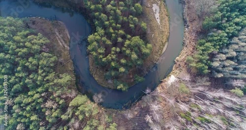 Winding Mala Panew river surrounded by forest, spinning overhead aerial photo