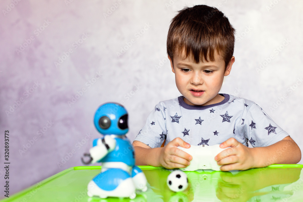 Little boy is playing with robot. Robot for children. Smart toy Little boy is playing with robot. Robot for children. Smart toy