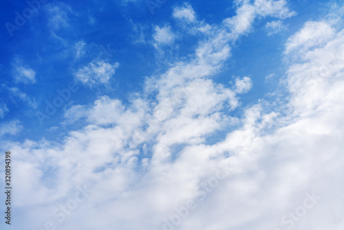 .White cumulus clouds against the background against blue on a blue background.
