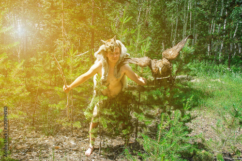 primitive man in the forest hunting with sitting on the arm of an eagle and a lynx skin photo