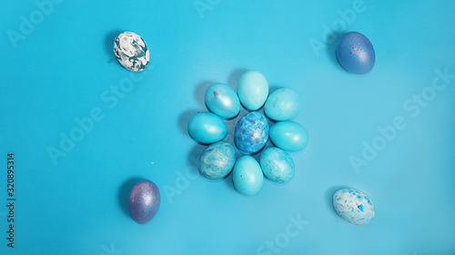 Decorated blue easter eggs on a turquoise background. Minimal holiday concept. Happy easter background. Creative painting of eggs at home  the idea of simple drawings for coloring  a place for text 
