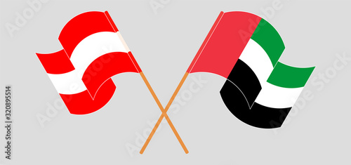 Crossed and waving flags of Austria and the United Arab Emirates