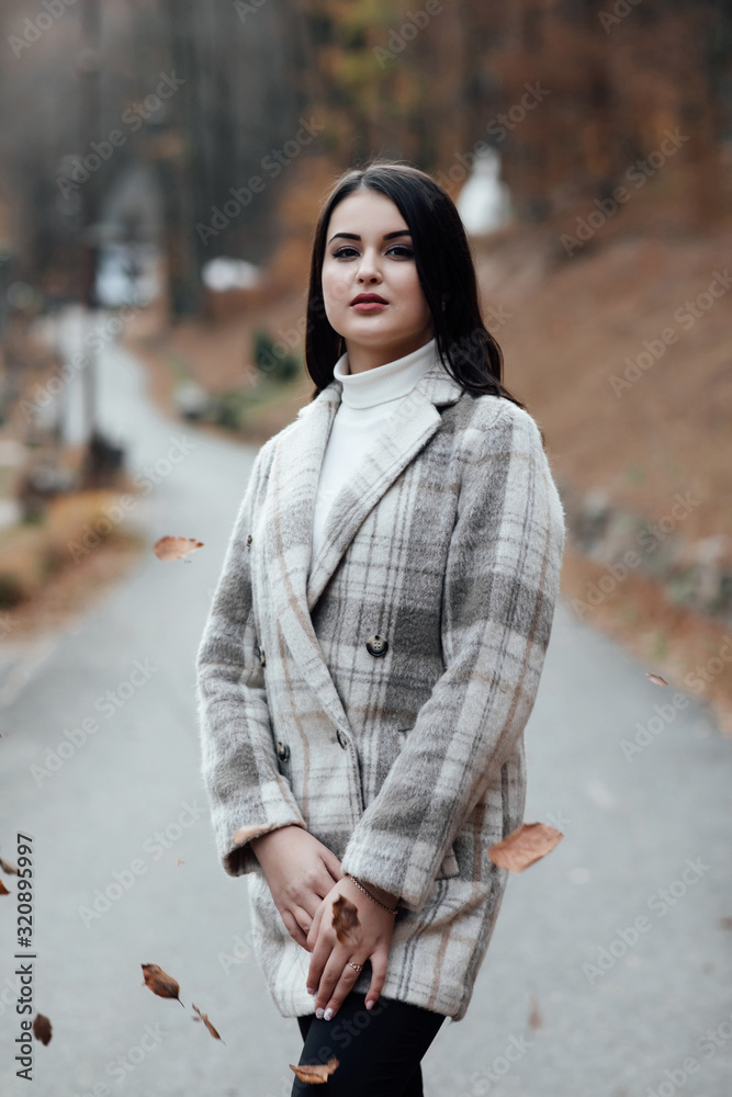 Fototapeta premium Beautiful attractive stylish woman walking in the street in warm coat, autumn fashion trend. Concept of fashion. Beautiful Teen Girl. 