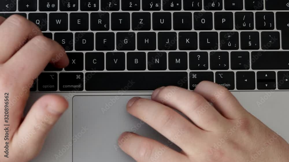 Man's hands writing on keyboard on computer Man's hands writing on keyboard on computer