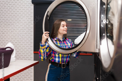 Photography self serviece laundrette client takes things out of the dryer