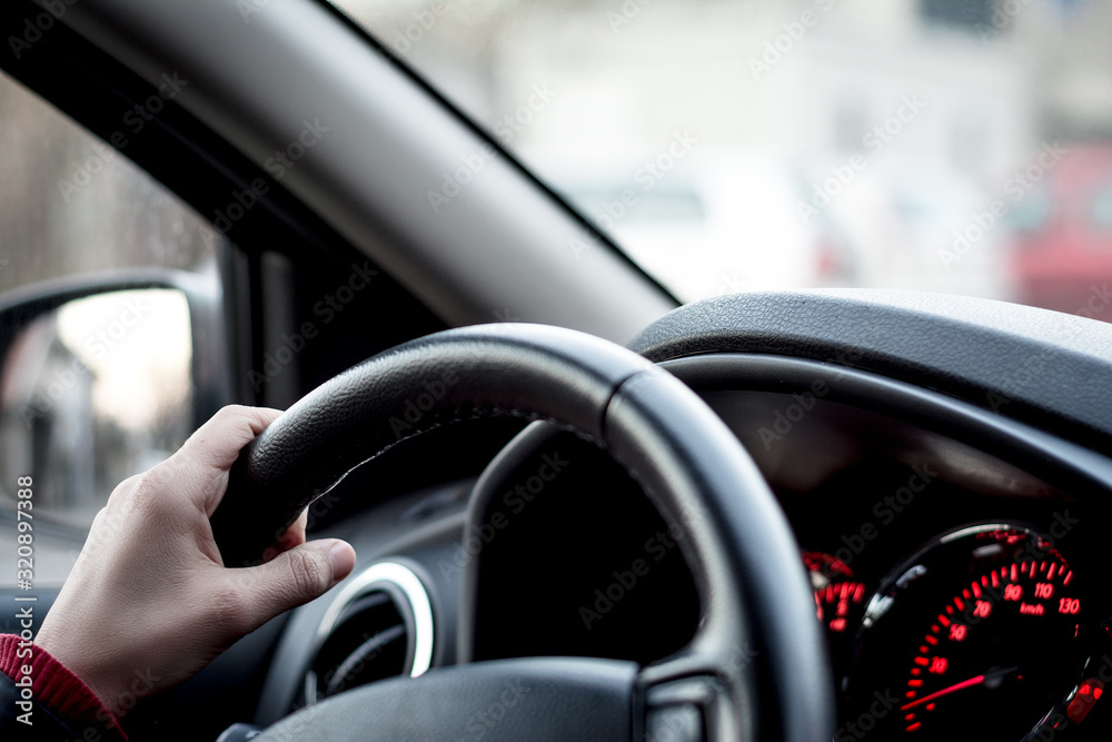 Woman's hands holding steering wheel in a car Woman's hands holding steering wheel in a car