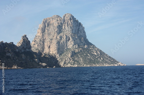 the islet of Es Vedra among the mist on the blue water of the ibiza sea