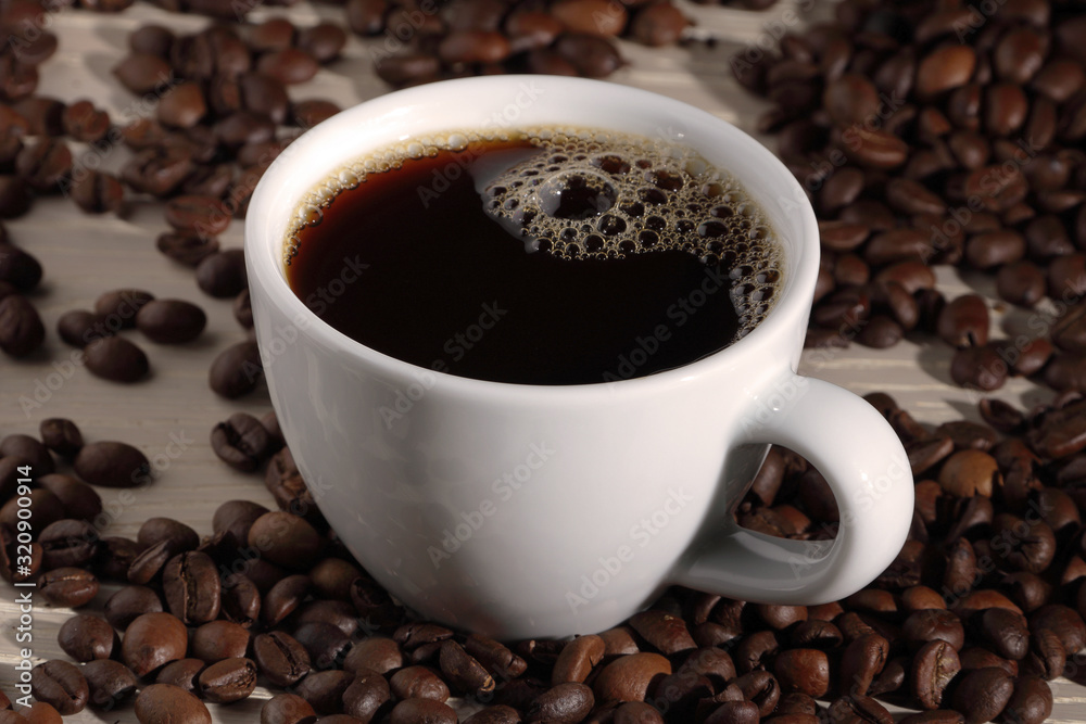 Cup of coffee with beans on wood Cup of coffee with beans on wood