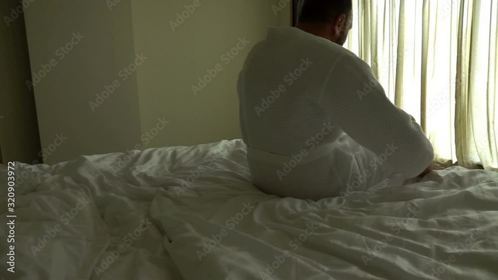 Young man waking up, walking towards window, unveil curtains, slow motion Young man waking up, walking towards window, unveil curtains, slow motion