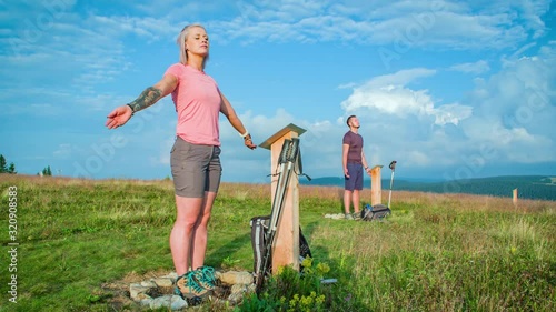 Two hikers standing peacefully on energy points in the hills of Slovenia photo