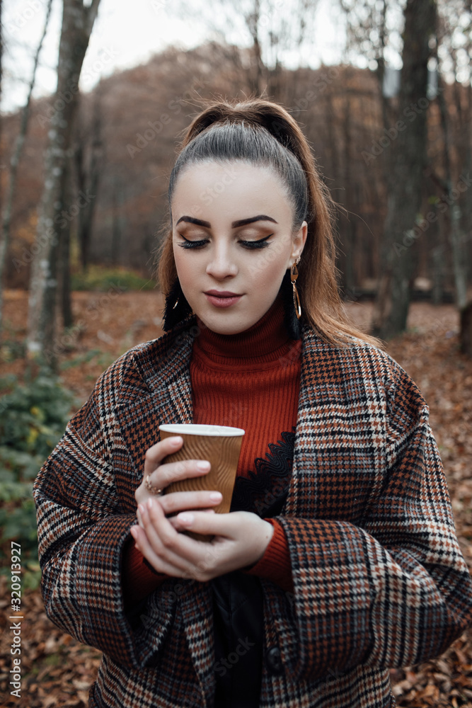 Portrait of beautiful brunette girl walking. Keeping takeaway drink in hands. Smiling. Outdoors. Concept of fashion. Beautiful Teen Girl Portrait of beautiful brunette girl walking. Keeping takeaway drink in hands. Smiling. Outdoors. Concept of fashion. Beautiful Teen Girl