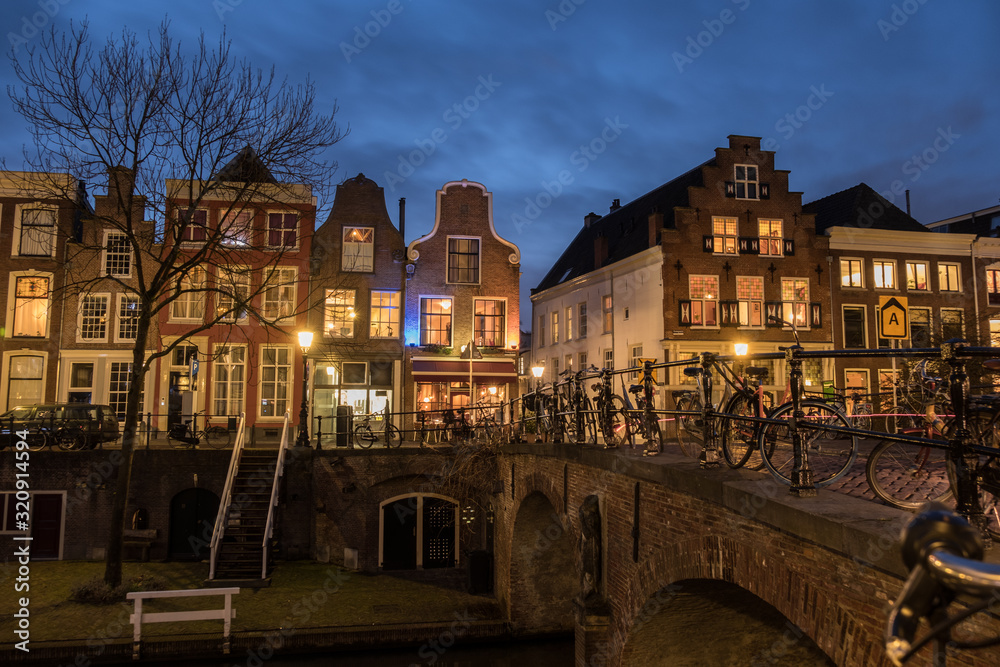 Fototapeta premium Kanał Utrecht Oudegracht nocą z oświetlonymi domami nad kanałem