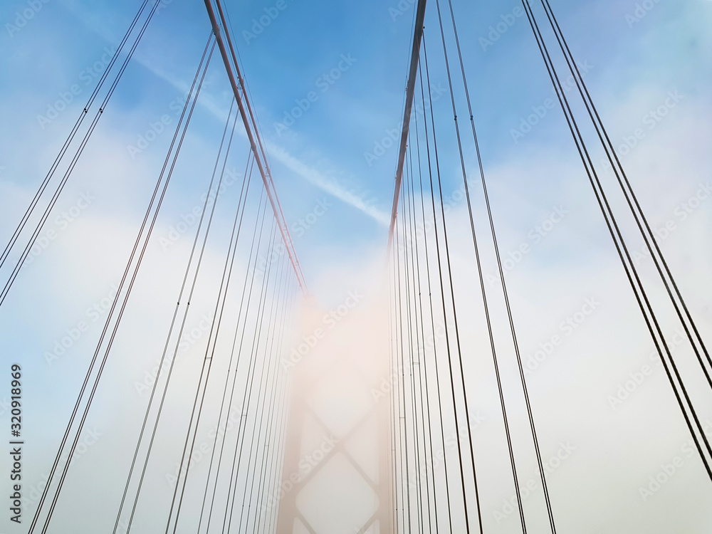 Architectural detail of suspension bridge on foggy day Architectural detail of suspension bridge on foggy day
