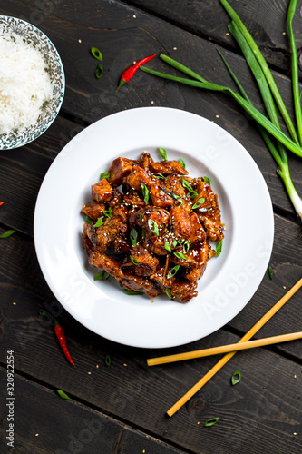 General Tso's Chicken vertical portrait top view. General Tso's chicken (also tsao or tao) is a popular chinese restaurant food with deep-fried crispy chicken covered in a tasty sweet and spicy sauce.