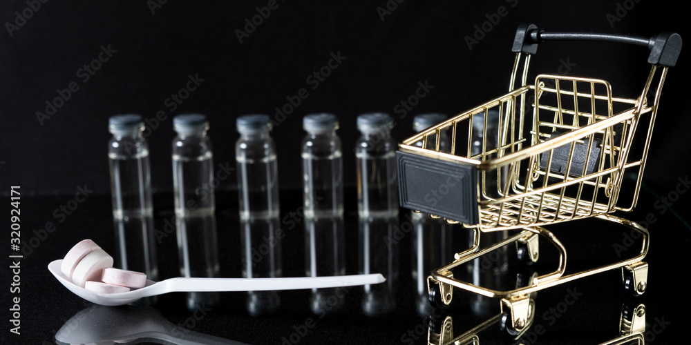 Medications and a gold cart in the concept of expensive medicine. With copy space.