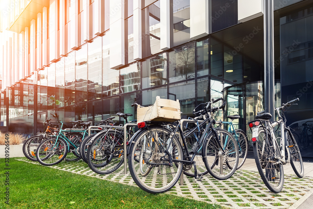 Many bike parked near modern apartment residential buiding or college campus at downtown of european city street. Eco-friendly transport and healthy active lifestyle concept. Sustainable work commute
