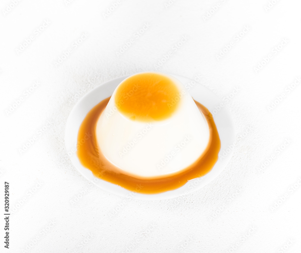 Italian dessert Panna cotta, creamy jelly with caramel sauce on a white background