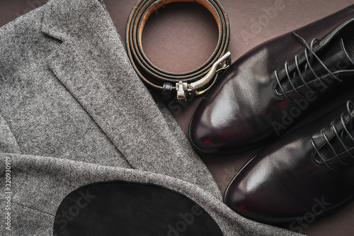 Close of fashionble men dark red leather shoes on tweed blazer background. photo