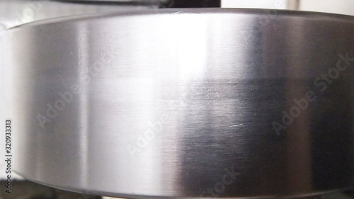 Metal roller or strip, part of a rolling machine. Metal axes and steel rollers in factory workshop. Iron texture industrial background