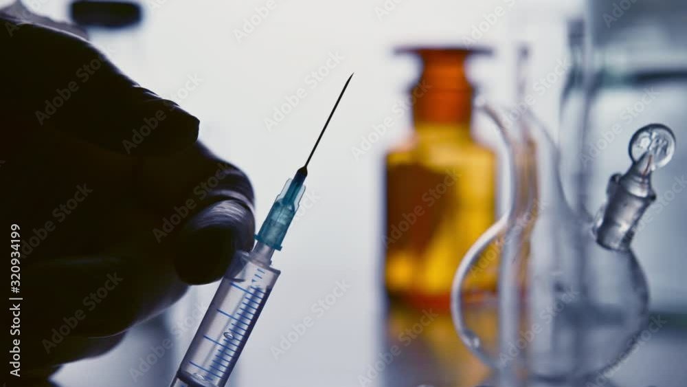Preparation of a syringe in the laboratory, hitting syringe with finger