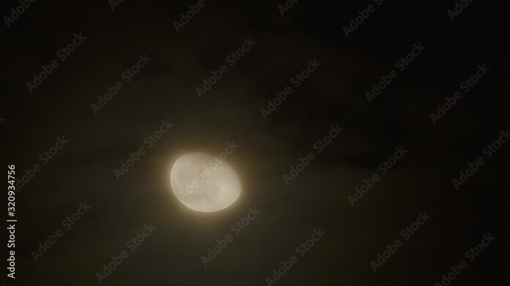 Incomplete Moon moves through the night sky, accompanied by small clouds. Incomplete Moon moves through the night sky, accompanied by small clouds.