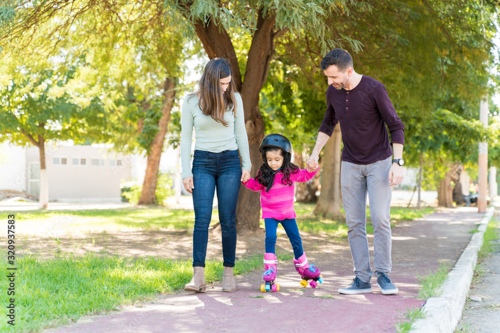Fototapeta premium Parents At Park Teaching Girl To Skate