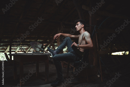 Portrait of mafia member model sitting at the table.