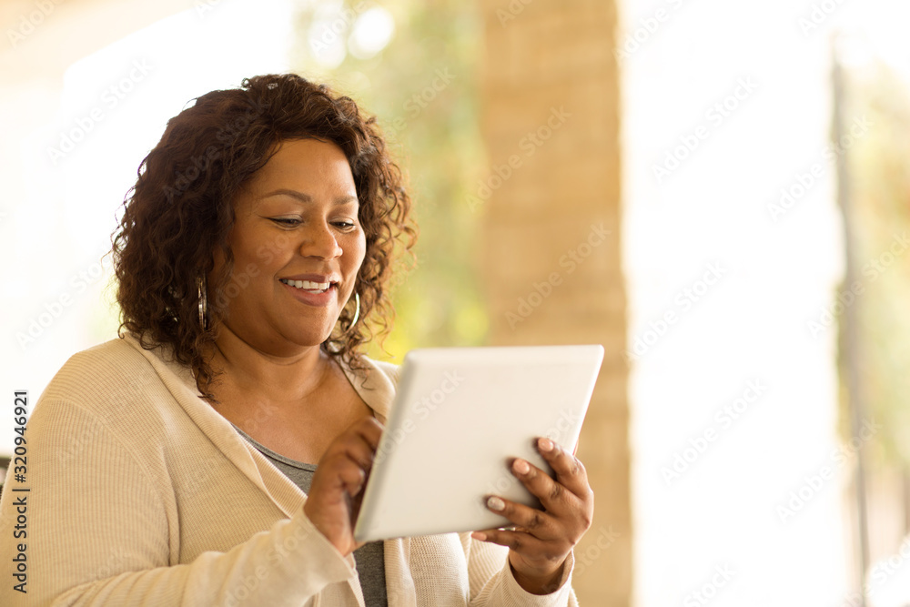 Smiling African American woman working on a tablet. Smiling African American woman working on a tablet.