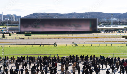 Crowd people watching monitors at racetrack