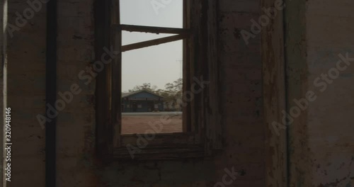 Looking through a window of an abandoned house through to a deserted country town photo