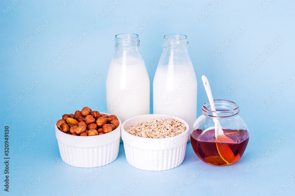 Healthy breakfast. Milk, honey, nuts and oatmeal on a blue background in the sunshine Healthy breakfast. Milk, honey, nuts and oatmeal on a blue background in the sunshine