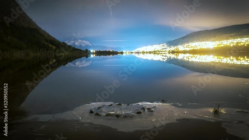 Nightlapse of a lake by a village. photo