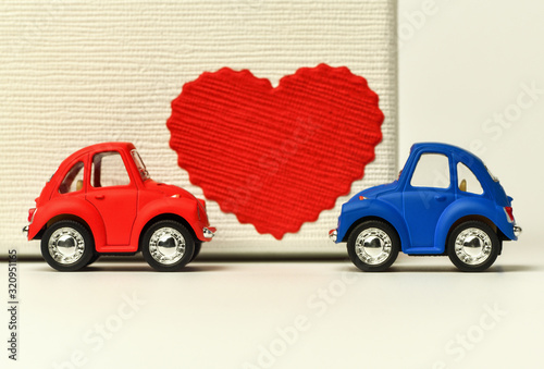 Valentines Day background.  Two small red and blue cars look at each other ,between them is a red heart.  Valentine's day, 8 March, International Happy Women's Day