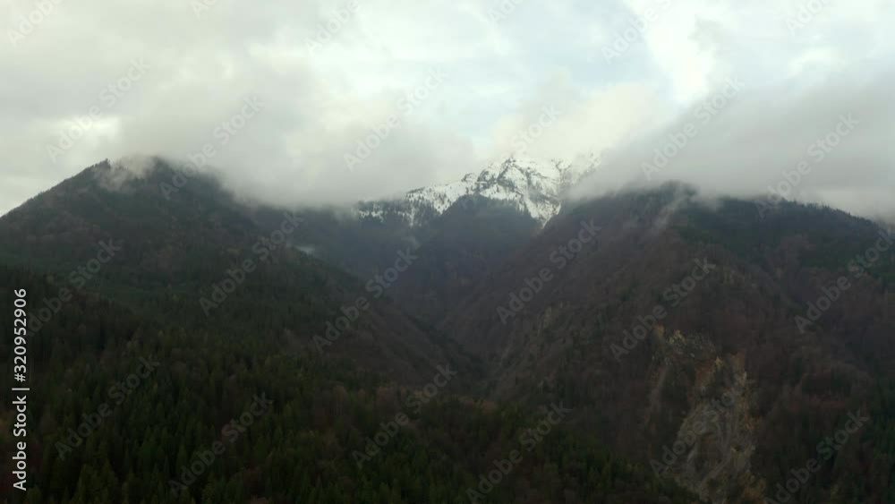 Aerial, tracking, drone shot over forest, of foggy mountains, low clouds, on a cloudy, fall day, near Cortina, in Dolomites, Italy Aerial, tracking, drone shot over forest, of foggy mountains, low clouds, on a cloudy, fall day, near Cortina, in Dolomites, Italy