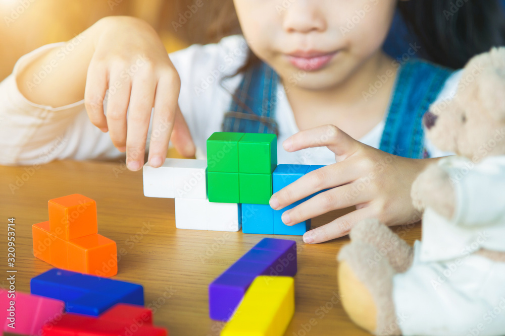 Close up part of a girl playing color wooden block on wooden table. Close up part of a girl playing color wooden block on wooden table.
