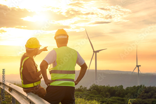 Two engineers discussed the plan for the maintenance of wind turbines. Renewable energy with wind generator by alternative energy concept in Asia