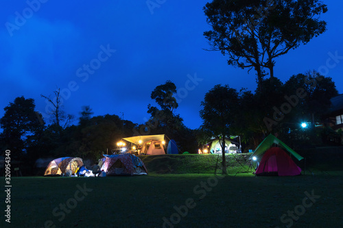 Night camping; blue shade sky in twilight time with silhouette of trees in the background.