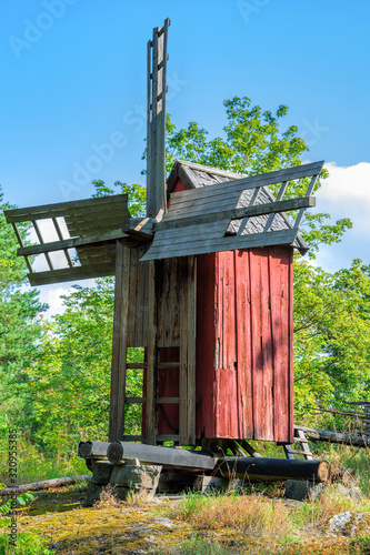 An old weathered wooden windmill painted in traditional falun red in the Local history museum in Pargas. Turku Archipelago, Finland. photo