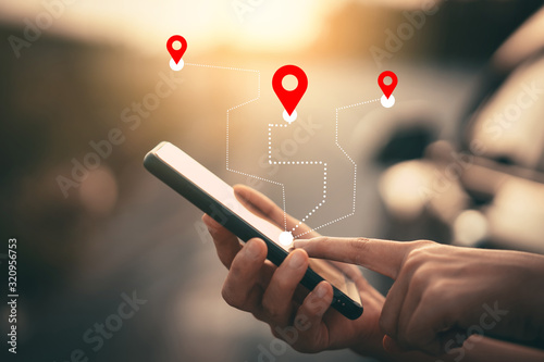 Man hand using smartphone with gps navigator map icon on blur street background. photo