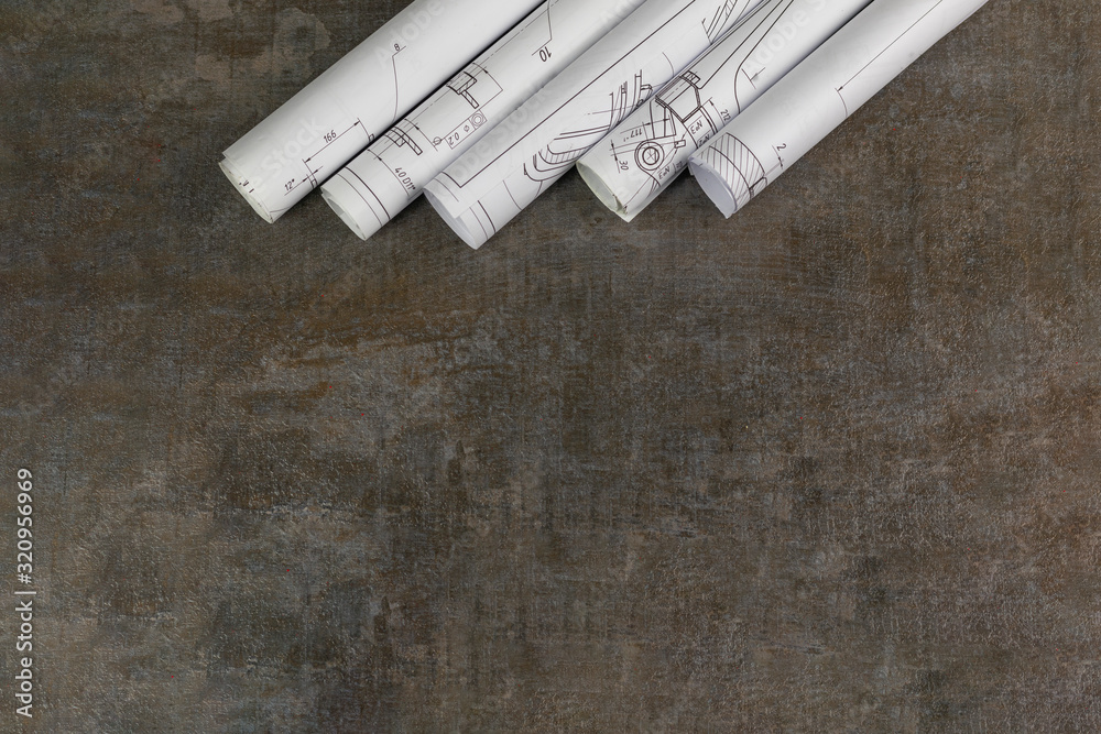 Wooden background. On it are blueprints or a plan of the future home or knowledge. They are rolled up. Wooden background. On it are blueprints or a plan of the future home or knowledge. They are rolled up.