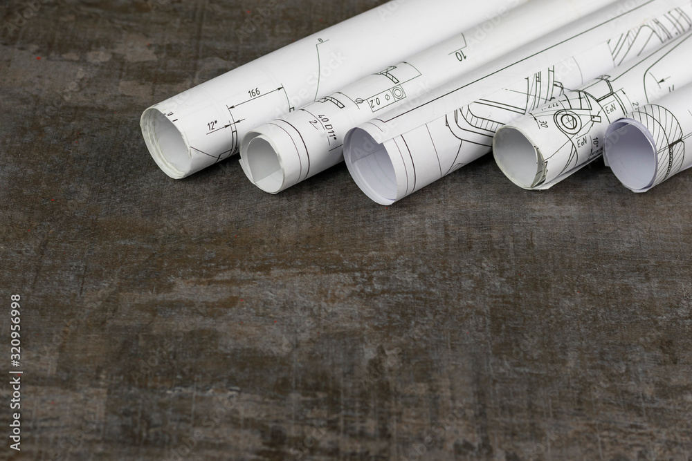 Wooden background. On it are blueprints or a plan of the future home or knowledge. They are rolled up. Wooden background. On it are blueprints or a plan of the future home or knowledge. They are rolled up.