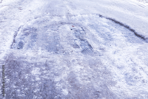 The bad asphalt winter road or way with ice, snow, puddles, pools, mud and slush © Майджи Владимир