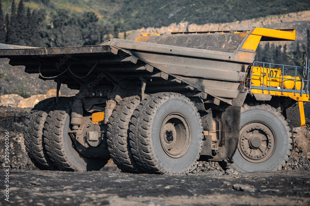 Big yellow mining truck empty body for anthracite. Open pit mine, extractive industry for coal Big yellow mining truck empty body for anthracite. Open pit mine, extractive industry for coal