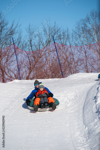 Obraz na płótnie Father and son snow tubing in the winter in Canada w salonie