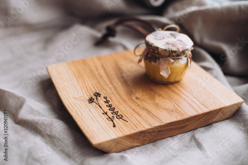 Wooden сutting board engraved with botanical pictures, wood board on linen surface 