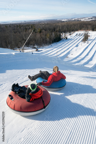 Obraz na płótnie Beautiful woman snow tubing with her son in the winter in Canada w salonie